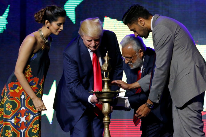 Republican Hindu Coalition Chairman Shalli Kumar (2nd R) helps Republican presidential nominee Donald Trump (2nd L) light a ceremonial diya lamp before he speaks at a Bollywood-themed charity concert put on by the Republican Hindu Coalition in Edison, New Jersey, U.S. October 15, 2016.