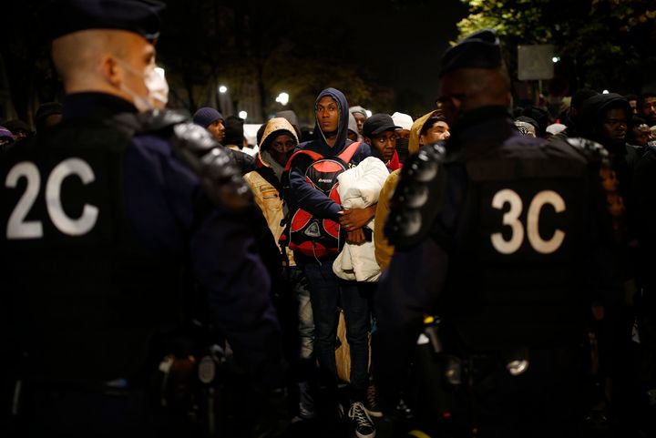 French police moved in at daybreak, and escorted migrants to dozens of buses from the sprawl of tents and mattresses gathered into makeshift camps in Paris.