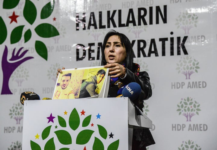 Figen Yuksekdag, co-leader of the pro-Kurdish Peoples' Democratic Party holds pictures of killed demonstrators at a funeral c
