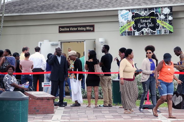 A group of people stand in line waiting to vote early outside the North Miami Public Library on Friday, Nov. 4, 2016.