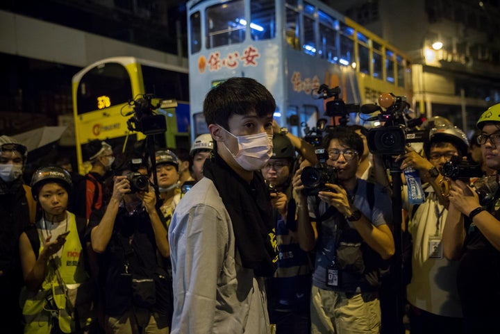 Newly elected lawmaker Baggio Leung (C) of Youngspiration stands in front of the press in Hong Kong early on November 7, 2016.