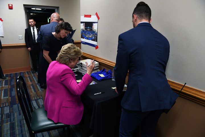Democratic presidential nominee Hillary Clinton signs books and photos for supporters backstage after a campaign rally in North Carolina.