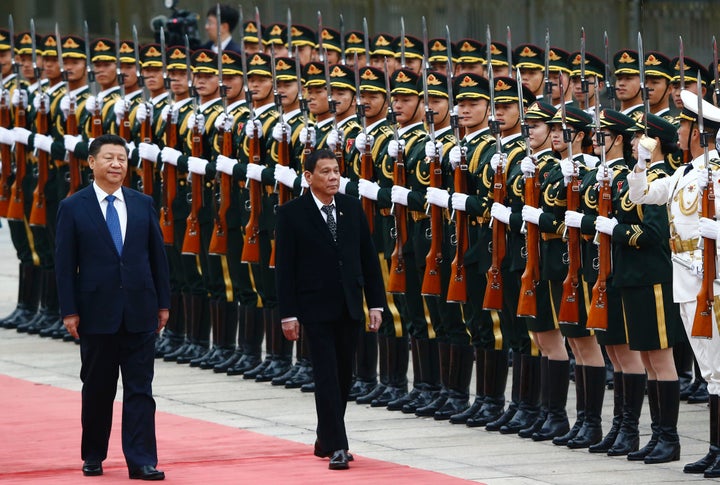 Philippine President Rodrigo Duterte (center) and Chinese President Xi Jinping attend a welcoming ceremony in Beijing. Dutert