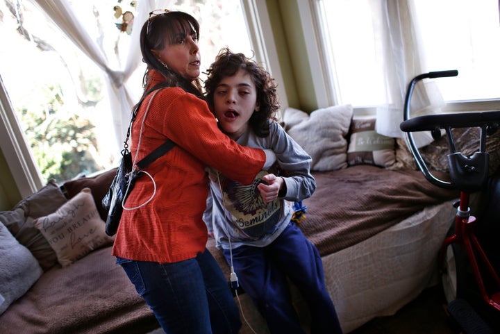 Missy Miller holds her epileptic son Oliver in their home at Atlantic Beach, New York, on Jan. 7, 2014. Oliver suffered a brain stem injury in utero and now, at 14, has hundreds of seizures a day. His family pinned their hopes on a strain of marijuana developed in Colorado that has helped children with similar conditions. 