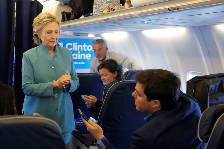 U.S. Democratic presidential nominee Hillary Clinton talks to traveling press secretary Nick Merrill onboard her campaign pla