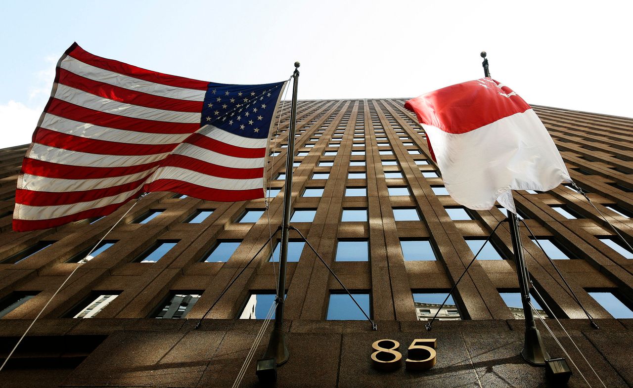 The flags of the U.S. and Singapore hang outside a building in New York.