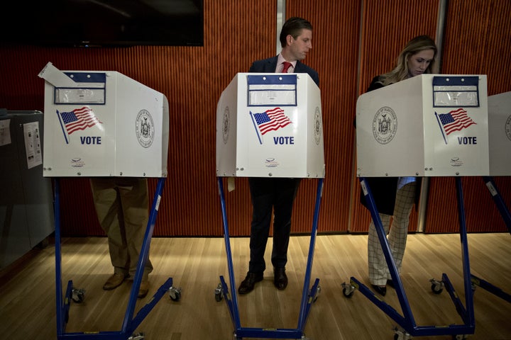 <strong>Eric Trump looks towards his wife Lara Yunaska's ballot paper as she votes</strong>