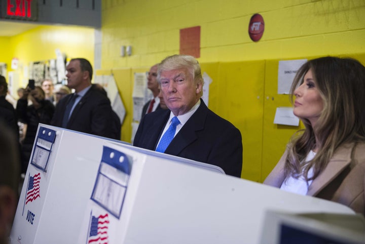 Republican presidential nominee Donald Trump(2nd R) and his wife Melania fill out their ballots at a polling station in a school during the 2016 presidential elections on November 8, 2016 in New York.