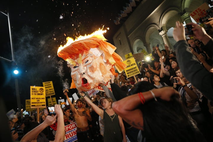 Protesters burn an effigy of Donald Trump outside Los Angeles City Hall