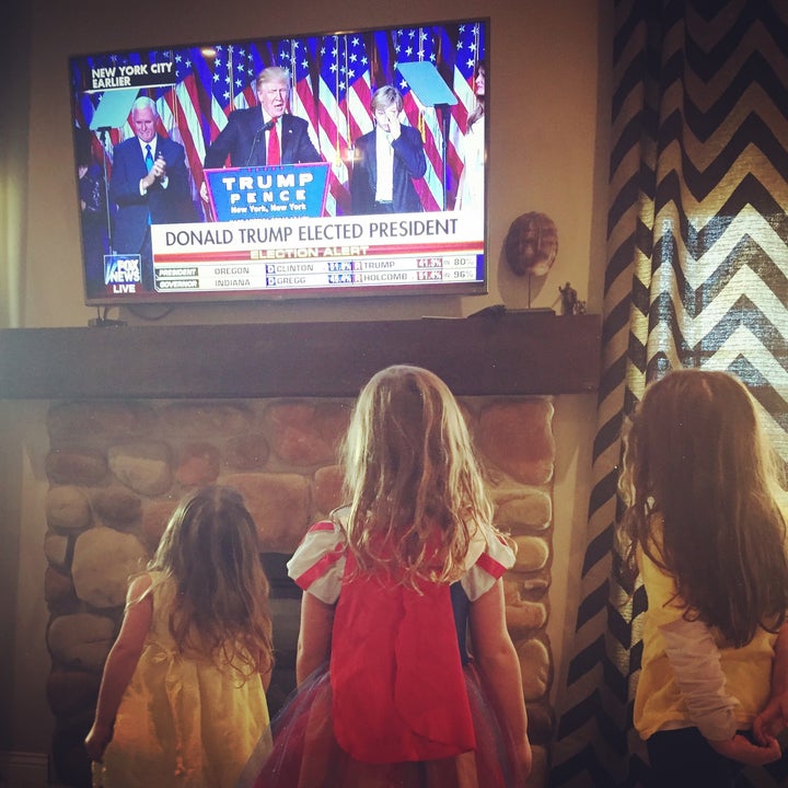 Three of my four daughters standing and staring at the television as Donald Trump is announced President Elect.