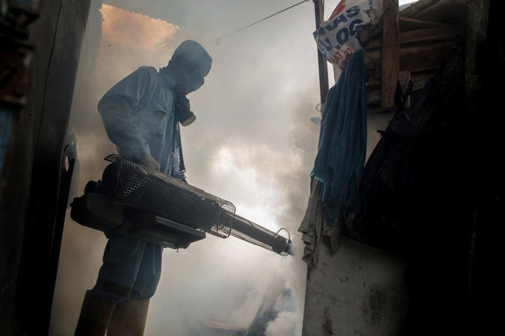 A health worker fogging densely populated areas in Indonesia, on Nov. 7. The fumigation is done to prevent the spread of the Aedes aegypti mosquito, which causes dengue during the rainy season.