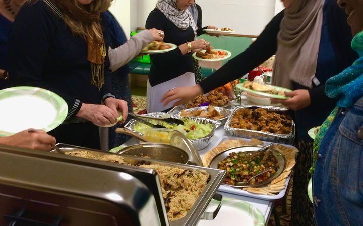 Twenty Muslim and Non-Muslim women share a meal.