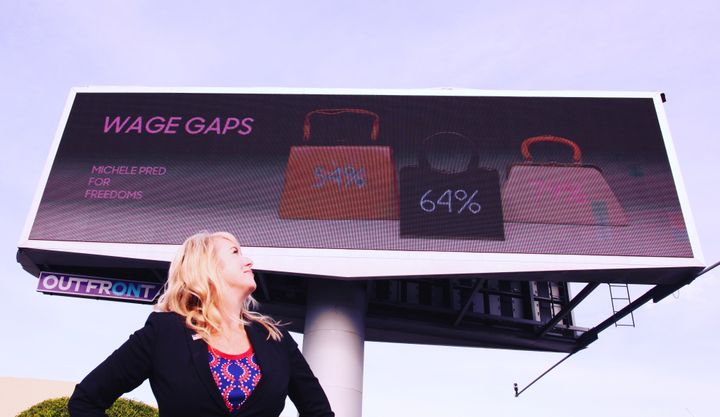 Billboard in Oakland, CA provided by For Freedoms featuring Michele Pred’s work. Each purse represents how much women make according to the color of their skin compared to white men by the dollar.