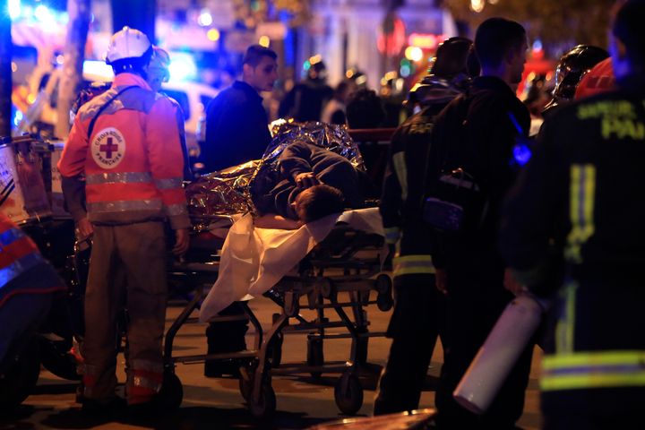 A person is being evacuated after a shooting, outside the Bataclan theater in Paris, Friday Nov 13, 2015.