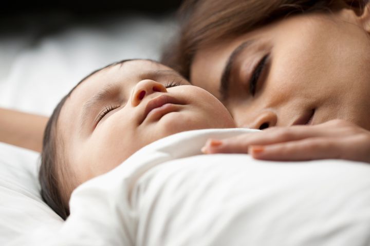 Mother with baby son (12-17 months) sleeping ImagesBazaar via Getty Images