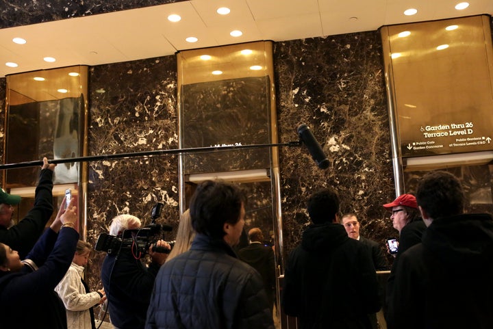 Michael Moore speaks to an attendant outside the lobby elevator bank in Trump Tower. He tried to arrange a meeting with the president-elect.