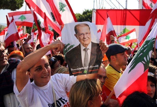 A Lebanese woman holds a picture of newly elected president Michel Aoun in Baabda, east of Beirut, Nov. 6, 2016.