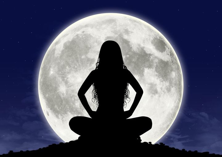 Young woman in meditation at the full moon.