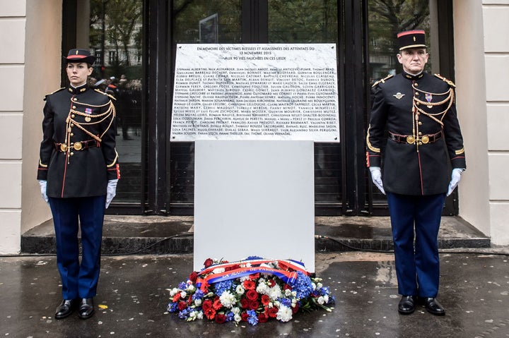 French Republican Guards stand next to a commemorative plaque reading "In memory of the injured and killed victims of the attacks of November 13, 2015 - to the 90 lives taken" at the Bataclan concert hall in Paris.