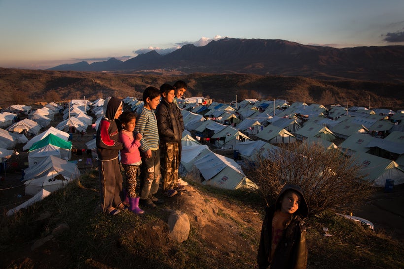 Children look out at the sunset over the Bamarne IDP camp in northern Iraq