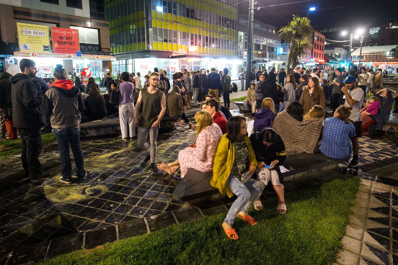 People wait in Te Aro Park after being evacuated from nearby buildings following an earthquake.