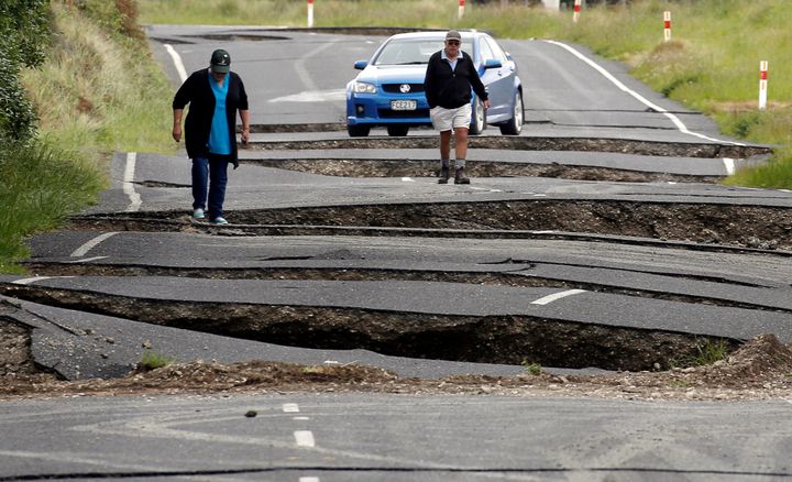 Local residents Chris and Viv Young look at damage caused by an earthquake, along State Highway One near the town of Ward, on New Zealand's South Island.