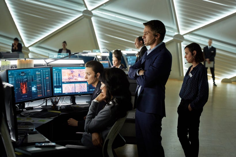 Olivier Martinez as Ed Grann the French CEO of the Mars Mission Corporation looks on over Jihae as Joon Seung the Korean-Amer