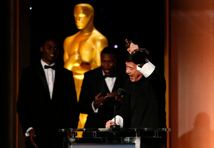 Chris Tucker looks on as Jackie Chan accepts his award.