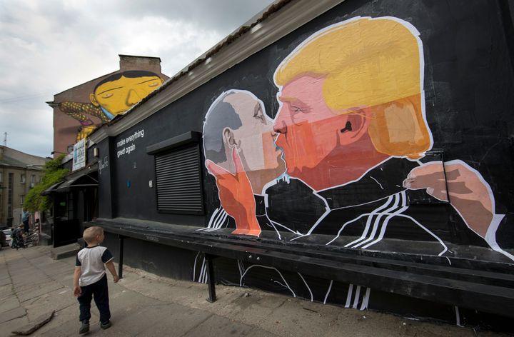 A child walks past graffiti depicting Putin and Trump in Vilnius, Lithuania, on May 14.