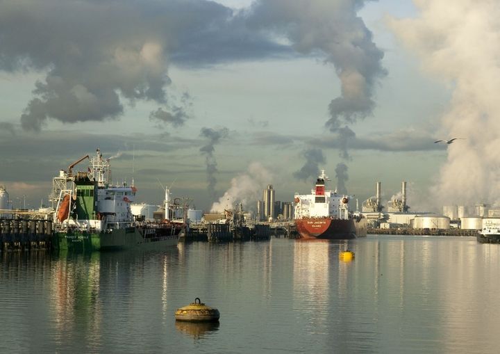 <p>Ships berthed in the Port of Rotterdam with refineries and fuel storage tanks in the background.</p>