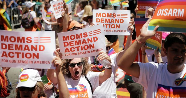 People hold signs while marching with the Moms Demand Action for Gun Sense in America contingent at the San Francisco LGBT Pride Parade in San Francisco, California, U.S. June 26, 2016.