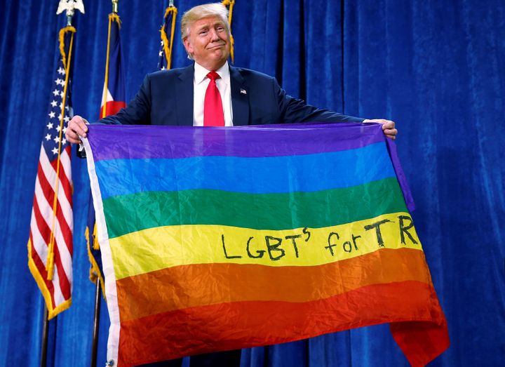 Republican presidential nominee Donald Trump holds up a rainbow flag with "LGBTs for TRUMP" written on it at a campaign rally in Greeley, Colorado, U.S. October 30, 2016.