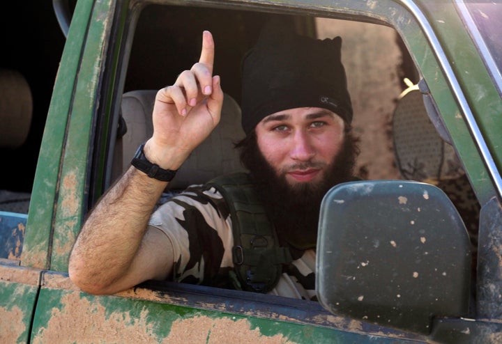 An Islamic State fighter gestures from a vehicle in the countryside of the Syrian Kurdish town of Kobani, In October 2014