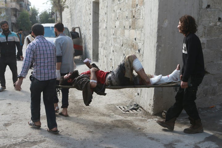 Syrians carry a wounded man after war crafts belonging to the Syrian and Russian army carried out airstrikes over residential areas in Aleppo, Syria on November 16, 2016.