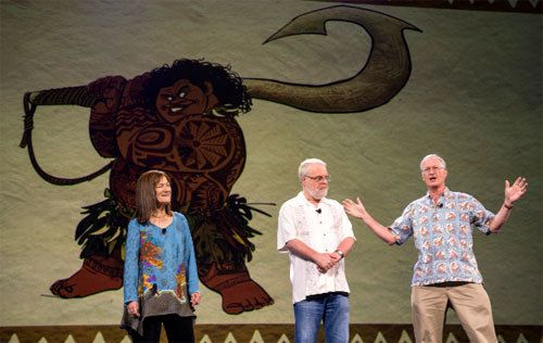 (L to R) Osnat Shurer, Ron Clements and John Musker stand in front of a piece of Maui character art.