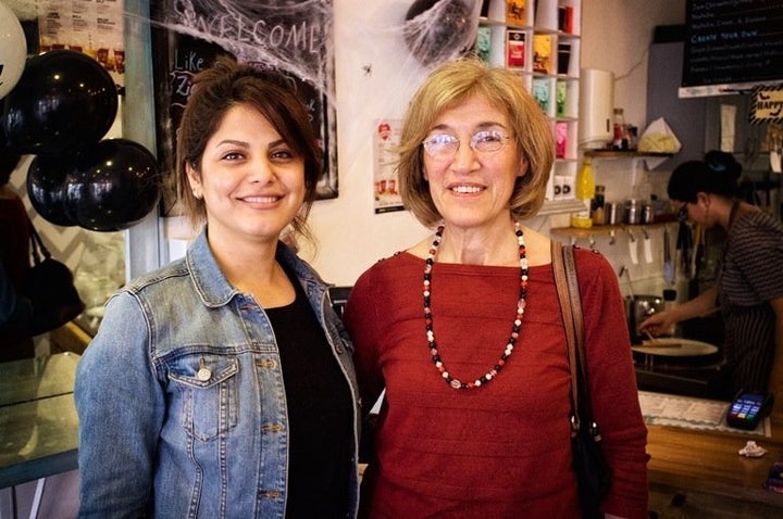 Niloofar from Iran, 23, is seen her with her local host Nina at the Zig Zag cafe in Epsom. She was granted permission to stay in the U.K. but is still waiting basics, such as her National Insurance card.