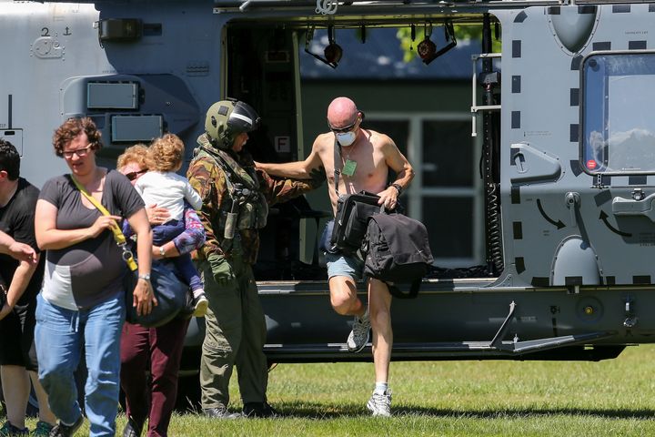 Military staff assist tourists trapped by the Kaikoura earthquakes as they arrive by military helicopters in Christchurch