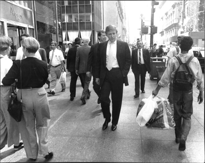 Walking down Fifth Avenue, Donald Trump goes unnoticed by sidewalk crowds during lunchtime on August 28, 1990.