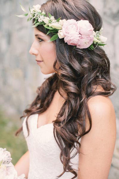 An asymmetrical floral crown calls attention to this bride's to-die-for mane.