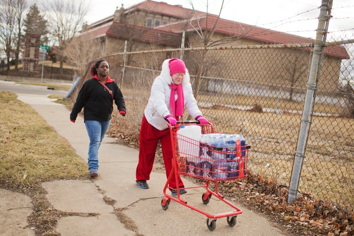 Virginia Mitchell, right, and her daughter-in-law Tiara Williams take bottled water home in February in Flint, Michigan. The state is fighting a judge's order to deliver water to Flint residents, whose have had lead-contaminated water since 2014. 