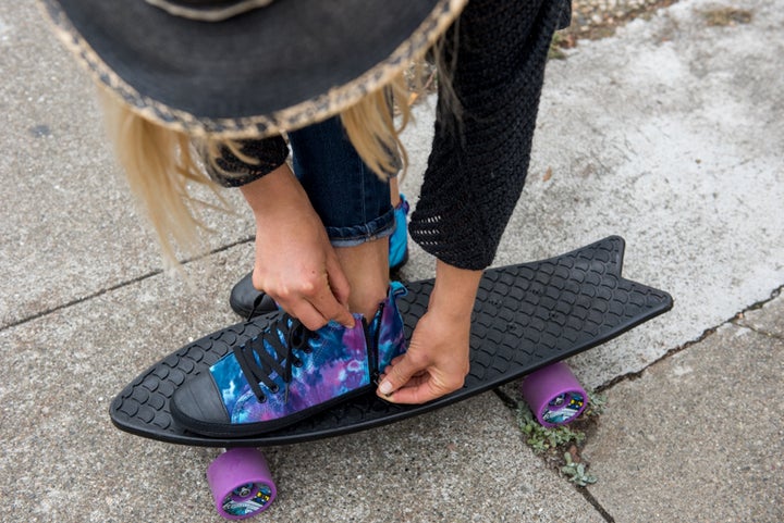 The “Kota” high top with repurposed tire soles, pictured with a recycled fishnet skateboard by Bureo.