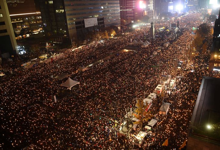 Protesters hold candles during an anti-government rally in central Seoul on November 19, 2016, aimed at forcing South Korean President Park Geun-Hye to resign over a corruption scandal.