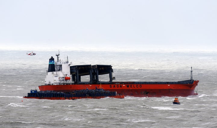 A coast guard helicopter attends the scene.