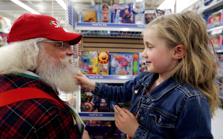 Claire, 5, tugs the beard of Santa Barry Westmoreland of Germanton, North Carolina, during the Santas field visit to a Toys R