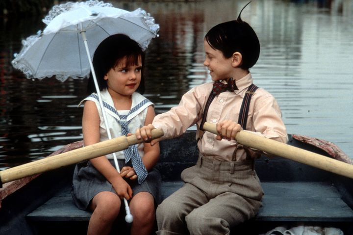 Bug Hall rowing a boat while looking at Brittany Ashton Holmes in a scene from the film "The Little Rascals," 1994.