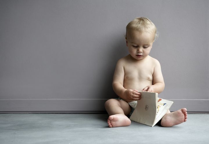 Baby boy (18-21 months) looking at book Alistair Berg via Getty Images