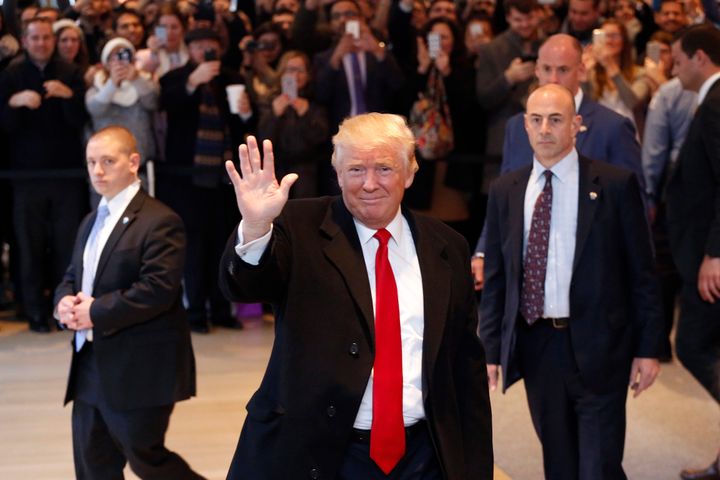 President-elect Donald Trump waves to the crowd as he leaves the New York Times building following a meeting