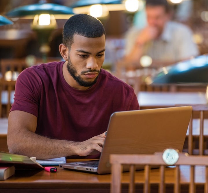 <p>Black collegiate man studying </p>
