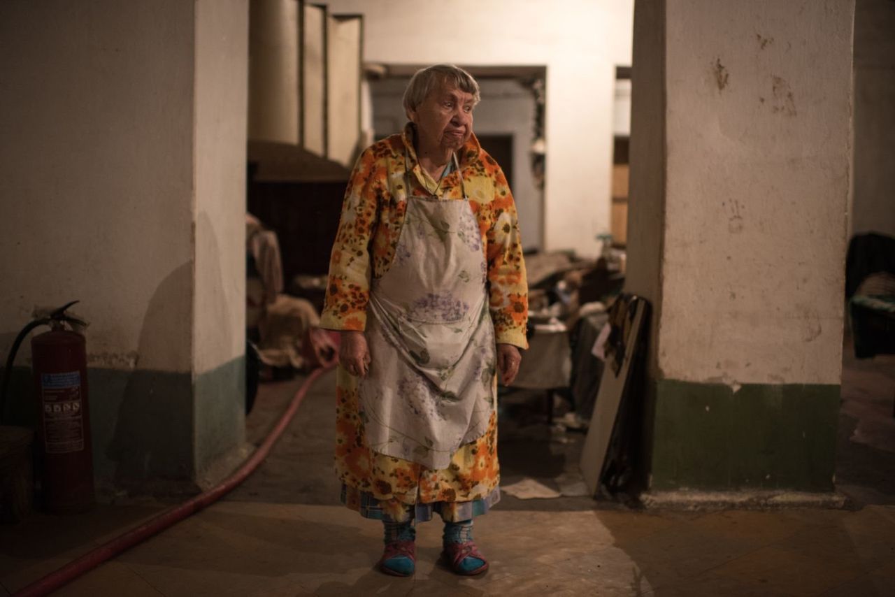 Mariya Tkachenko, 85, prepares and eats her meal in the bunker’s kitchen area.