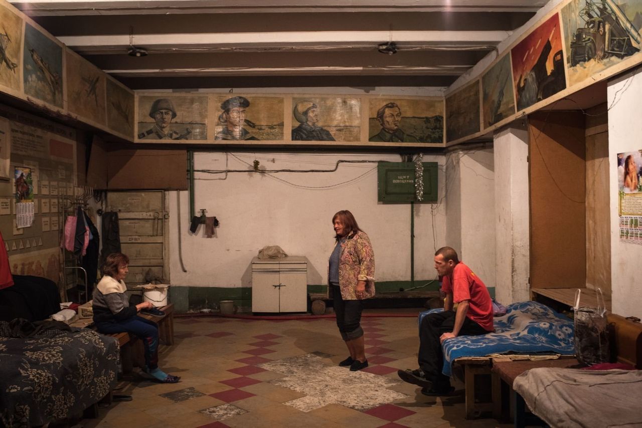 Valentina Maronova, center, stands in the main common area inside the bunker. She is concerned about the looming winter season and lack of heaters in the underground space.